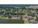 Aerial view of a lakeside home featuring a screened-in pool and mature landscaping at 3314 Cypress Landing Dr, Valrico, FL 33596