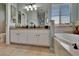 Bathroom boasts double sinks, white cabinets, granite countertops, and a soaking tub at 3314 Cypress Landing Dr, Valrico, FL 33596