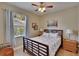 Cozy bedroom with a large window, wooden bed frame, side tables and warm, neutral wall colors at 3314 Cypress Landing Dr, Valrico, FL 33596
