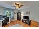 Comfortable bedroom with hardwood floors, ceiling fan, natural light, and an adjacent workstation at 3314 Cypress Landing Dr, Valrico, FL 33596