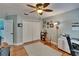 Comfortable bedroom featuring hardwood floors, ceiling fan and an adjacent workstation at 3314 Cypress Landing Dr, Valrico, FL 33596
