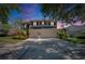 Two-story home featuring a three-car garage, large driveway and dusk lighting at 3314 Cypress Landing Dr, Valrico, FL 33596