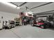 Spacious garage with painted floors, storage racks, and overhead lights with a golf cart at 3314 Cypress Landing Dr, Valrico, FL 33596