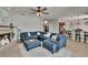 A cozy living area opens to a modern kitchen with bar seating and comfortable blue sofas at 3314 Cypress Landing Dr, Valrico, FL 33596