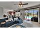 Comfortable living room featuring a plush blue sectional sofa, ceiling fan and a view of the outdoor pool area at 3314 Cypress Landing Dr, Valrico, FL 33596