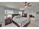 Spacious bedroom with two large windows, a ceiling fan, dark wooden furniture, and neutral colored walls at 3314 Cypress Landing Dr, Valrico, FL 33596