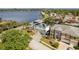 Waterfront home featuring solar panels, lush landscaping, and a multi-car driveway near a serene lake at 339 Manatee Ln, Tarpon Springs, FL 34689