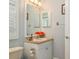 Bathroom featuring a vanity with granite countertop, decorative mirror, and a view of the window with blinds at 339 Manatee Ln, Tarpon Springs, FL 34689