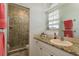 Bathroom featuring granite countertops, a large mirror, and a tiled shower at 339 Manatee Ln, Tarpon Springs, FL 34689