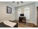 This bedroom features a dark wood floor, two arched windows and a ceiling fan at 339 Manatee Ln, Tarpon Springs, FL 34689