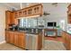 Kitchen with stainless steel dishwasher, dark countertops, and cabinets with a view of the living room area at 339 Manatee Ln, Tarpon Springs, FL 34689