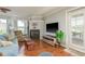 Bright living room with a fireplace, wood floors, and a large window with shutters at 339 Manatee Ln, Tarpon Springs, FL 34689