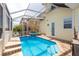 Backyard pool and hot tub, surrounded by a screened enclosure and a yellow house at 339 Manatee Ln, Tarpon Springs, FL 34689