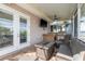 A screened porch with white doors, TV, an outdoor kitchen, and water view at 339 Manatee Ln, Tarpon Springs, FL 34689