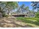 Spacious backyard with lush green grass and a screened-in porch, ideal for outdoor relaxation at 37348 Tucker Rd, Zephyrhills, FL 33541