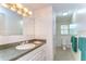 Well-lit bathroom features a single sink vanity with storage, and an adjacent room contains toilet and shower/tub at 37348 Tucker Rd, Zephyrhills, FL 33541