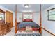Spacious bedroom with dark wood four poster bed, abundant natural light, with an adjacent closet for storage at 37348 Tucker Rd, Zephyrhills, FL 33541