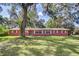 Charming single-story brick home featuring a lush green lawn and mature trees at 37348 Tucker Rd, Zephyrhills, FL 33541