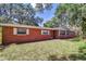 Brick home with lush lawn and mature trees providing ample shade at 37348 Tucker Rd, Zephyrhills, FL 33541
