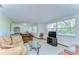 Bright living room with large windows, comfortable seating, and neutral carpet at 37348 Tucker Rd, Zephyrhills, FL 33541
