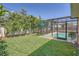 A well-manicured backyard with green grass and a screened-in pool area at 4018 Indianapolis Ne St, St Petersburg, FL 33703