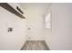 Bright laundry room with a window, utility connections, floating shelf, and gray tile flooring at 4018 Indianapolis Ne St, St Petersburg, FL 33703