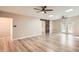 Open-concept living room with laminate floors, ceiling fans, and a modern sliding barn door feature at 4018 Indianapolis Ne St, St Petersburg, FL 33703