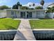 Beautiful backyard with lush green lawn, patio and dock for waterfront living at 419 12Th Ave, Indian Rocks Beach, FL 33785