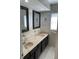Well-lit bathroom featuring a double sink vanity with a marble countertop and tiled backsplash at 419 12Th Ave, Indian Rocks Beach, FL 33785