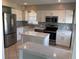 Modern kitchen featuring white cabinets, stainless steel appliances, and an island with quartz countertops at 419 12Th Ave, Indian Rocks Beach, FL 33785