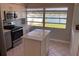Bright kitchen featuring stainless steel appliances, an island, and large window with a water view at 419 12Th Ave, Indian Rocks Beach, FL 33785