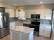 Modern kitchen featuring stainless steel appliances, an island, white cabinets, and stylish tile backsplash at 419 12Th Ave, Indian Rocks Beach, FL 33785
