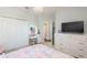 Well-lit bedroom featuring closet, vanity and desk, television and neutral carpeting at 4204 W San Juan St, Tampa, FL 33629
