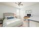 Neutral bedroom featuring a ceiling fan, a bed with decorative pillows, and a wooden desk workstation at 4204 W San Juan St, Tampa, FL 33629