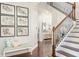 Inviting foyer with hardwood floors, a staircase with ornamental iron railings, and a bench beneath botanical wall art at 4204 W San Juan St, Tampa, FL 33629