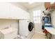 Clean laundry room featuring a washer, dryer, sink, and storage cabinets at 4204 W San Juan St, Tampa, FL 33629