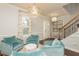 Cozy living room with plush armchairs, decorative lighting, and staircase view at 4204 W San Juan St, Tampa, FL 33629