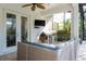 Outdoor kitchen under covered patio with built in BBQ grill, stainless steel refrigerator and wicker furniture at 4204 W San Juan St, Tampa, FL 33629