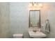 Charming powder room with patterned wallpaper, a decorative mirror, and elegant fixtures at 4204 W San Juan St, Tampa, FL 33629