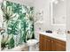 Tropical-themed bathroom with a vanity, shower, and vibrant botanical print curtain at 4215 E Bay Dr # 1806D, Clearwater, FL 33764