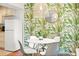 Dining area with leafy wallpaper, a stylish pendant light, and an adjacent kitchen area at 4215 E Bay Dr # 1806D, Clearwater, FL 33764