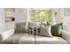 Cozy living room featuring a comfortable sofa with stylish pillows and a leafy wallpaper accent wall at 4215 E Bay Dr # 1806D, Clearwater, FL 33764