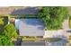 Aerial view of house with well-maintained gray roof, driveway, and lush surrounding trees at 6328 S Harold Ave, Tampa, FL 33616