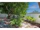 Landscaped backyard features a brick patio, lush plants, and a privacy fence at 6328 S Harold Ave, Tampa, FL 33616