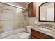 Bathroom featuring a granite-topped vanity, glass-enclosed shower, and storage cabinet at 6328 S Harold Ave, Tampa, FL 33616