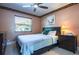 Cozy bedroom features a ceiling fan, window, and a comfortable bed with side tables at 6328 S Harold Ave, Tampa, FL 33616