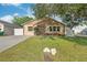 Inviting single-story home with a green lawn, mature landscaping, and a long driveway leading to the front entrance at 6328 S Harold Ave, Tampa, FL 33616