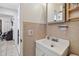 Cozy bathroom featuring a white vanity, tiled walls and open doorway to an adjacent room at 8431 52Nd N Way, Pinellas Park, FL 33781