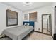 Bedroom featuring a blue bed frame, tiled flooring, and bright natural light from two windows at 8431 52Nd N Way, Pinellas Park, FL 33781