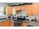 Kitchen with stainless steel oven and warm wood cabinets offers ample storage and cooking space at 8431 52Nd N Way, Pinellas Park, FL 33781